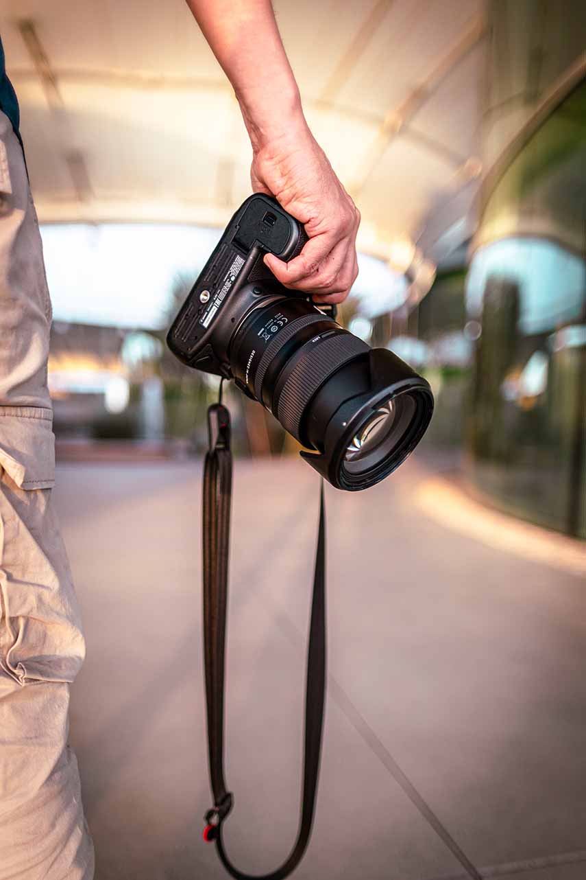 Photographe vidéaste tenant un appareil photo professionnel pendant un reportage photo et vidéo